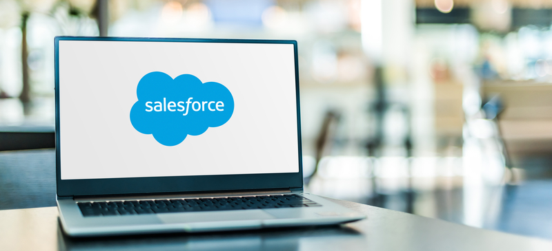 A laptop on a desk displays the Salesforce logo