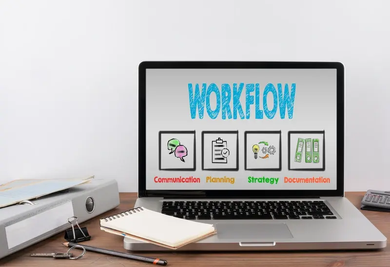 A laptop on a desk shows the word